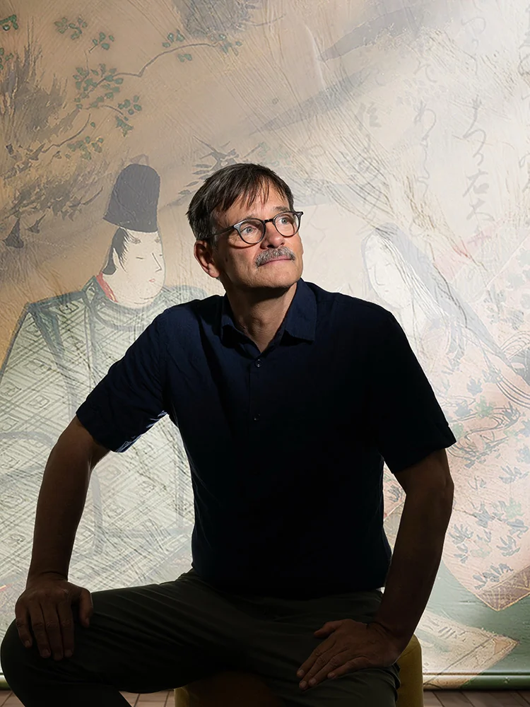 A scholar examining ancient Japanese texts as part of a digital archiving project